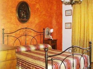 1 dormitorio con 1 cama con pared de color naranja en Le Perine, en Valdobbiadene