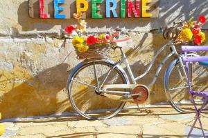 un vélo avec un panier rempli de fleurs fixé à un mur dans l'établissement Le Perine, à Valdobbiadene