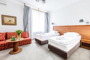 una camera d'albergo con due letti e un divano di Hotel Pod Złotą Różą a Kielce