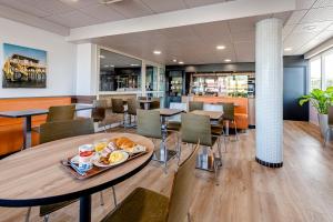 グラディニャンにあるB&B HOTEL Bordeaux Talenceのダイニングルーム(テーブル、食器付)