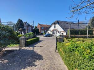 a brick driveway with a gate in a residential neighborhood at Chapeau ! in Garderen +21 photos