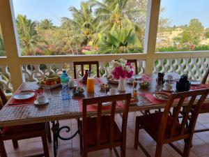 - une table avec de la nourriture et des fleurs sur le balcon dans l'établissement Le Souimanga Hotel Saly, à Saly Portudal