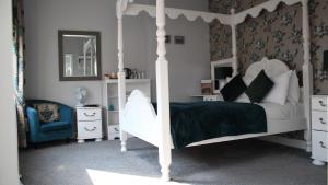 a bedroom with a white canopy bed and a blue chair at The Whittington and Cat in Hull