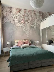 1 dormitorio con 1 cama con edredón verde en Apartament biały z jacuzzi, en Cracovia