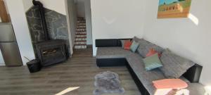 a dog laying on the floor in a living room with a couch at Apartman Lynx on lake Sabljaci in Ogulin
