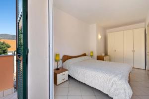Un dormitorio con una cama y un balcón. en Appartamento Ferla La Taggiasca, en Stellanello