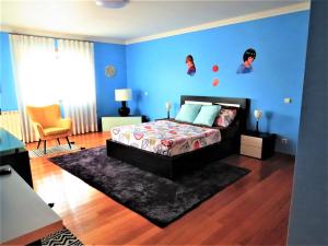 1 dormitorio con cama y pared azul en Anjos’home, en Viana do Castelo