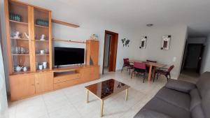 uma sala de estar com um sofá, uma televisão e uma mesa em Mar i Angels Apartament em Pineda de Mar