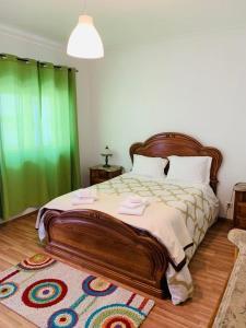 1 dormitorio con 1 cama grande y cortina verde en Anjú-Pardal, en Mogadouro