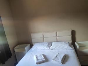 1 dormitorio con 1 cama con 2 almohadas en And Marlebi en Cabo Frío