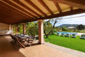 a patio with a table and chairs and a pool at Finca Port Vert in Son Servera