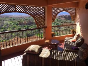 een kamer met 2 stoelen en een balkon met uitzicht bij Kasbah Itran in Kalaat MGouna