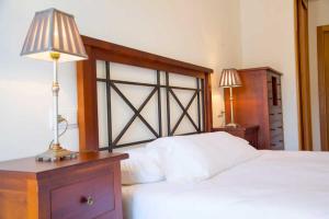 a bedroom with a bed and a lamp on a dresser at Apartamento Welcome Portonovo Playa in Sanxenxo