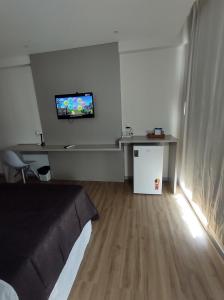 a room with a bed and a tv on the wall at Apart Hotel - Campos dos Goytacazes in Campos dos Goytacazes