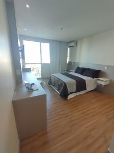 una camera da letto con un letto e una scrivania con un computer portatile di Apart Hotel - Campos dos Goytacazes a Campos dos Goytacazes