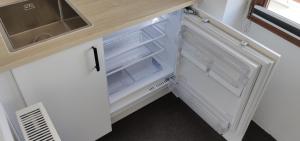 un piccolo frigorifero con la porta aperta in cucina di Kleines aber feines Apartment a Gelsenkirchen