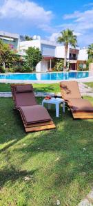 - deux chaises longues et une table à côté de la piscine dans l'établissement A Villa For only 90 day and more days, à Antalya