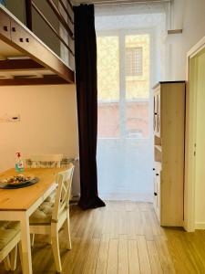 een eetkamer met een tafel en een groot raam bij Maelle Trastevere in Rome