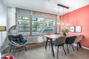 uma sala de jantar com uma cadeira de baloiço e uma mesa em Ruim, rustgevend glv app met warme kleuraccenten em Middelkerke