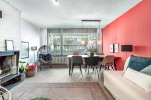 sala de estar con mesa y pared roja en Ruim, rustgevend glv app met warme kleuraccenten en Middelkerke