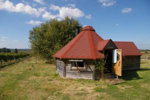 uma pequena casa com um telhado vermelho num campo em village privatisé de cabanes insolites d'Ananda Ma em Saint-Aubin-de-Lanquais