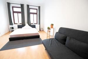 - un salon avec un canapé et un lit dans l'établissement Schloßchemnitz-tolle Ferienwohnung mit Balkon, à Chemnitz