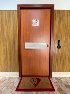uma porta de madeira com uma placa com um tapete na frente em B&B Casa Rubino em Nápoles