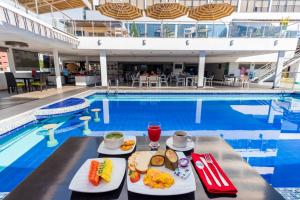 a tray of food sitting next to a swimming pool at Hotel Chicamocha in Bucaramanga