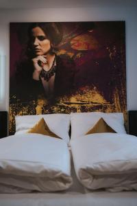 a painting on the wall above a bed with white pillows at Sombea in Villingen-Schwenningen
