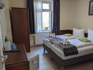 a bedroom with two beds and a table and a window at Pension Celia in Wismar
