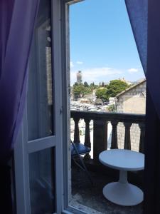 a view of a balcony with a table and a stool at Rooms Milena in Lopud