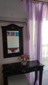 a room with a mirror and a table with flowers at Rooms Milena in Lopud Island
