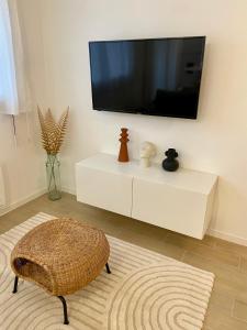 ein Wohnzimmer mit einem TV auf einem weißen Schrank in der Unterkunft La ROSERAIE in Mont-de-Marsan