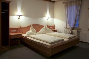 a bedroom with a bed with white sheets and a window at Brauereigasthof Hotel Schlüssel in Giengen an der Brenz