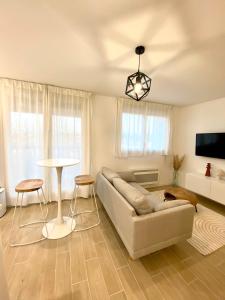 a living room with a couch and a table at La ROSERAIE in Mont-de-Marsan