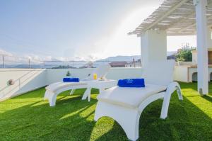 ArkhondikíにあるAngelos House Spa & Hammamの屋根の芝生に座る白いベンチ2つ