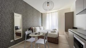 a bedroom with a bed and a table and a mirror at Italianway - The B Village Business in Milan