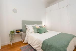 een slaapkamer met een groot bed en witte kasten bij Charming Apartment in Private Condominium at Graça in Lissabon