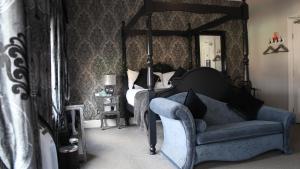 a bedroom with a four poster bed and a chair at The Whittington and Cat in Hull