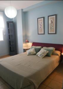 a bedroom with a large bed with two pillows at Islantilla Casa Adosada 700 metros de la playa in Islantilla