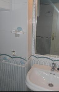 un bagno con lavandino e specchio di Islantilla Casa Adosada 700 metros de la playa a Islantilla