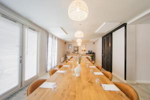 a long table in a room with chairs and windows at Stadsvilla Hotel Mozaic Den Haag in The Hague