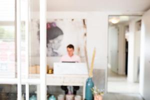 a man sitting at a desk using a laptop computer at Stadsvilla Hotel Mozaic Den Haag in The Hague +32 photos