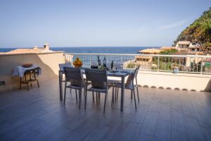 un tavolo e sedie su un balcone con vista sull'oceano di Can MarSal Puerto Valldemosa a Valldemossa