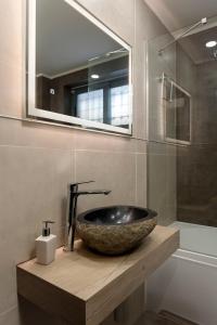 a bathroom with a stone sink and a mirror at Bozikis Villa in Kalpaki