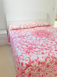 a bed with a red and white blanket on it at Villa“La Salentina” in Castrignano del Capo
