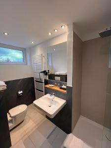 a bathroom with a sink and a toilet at Hotel-Restaurant Amadeus in Hannover