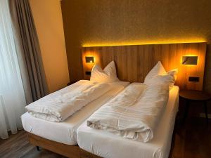 1 Schlafzimmer mit 2 Betten mit weißen Decken und Kissen in der Unterkunft Hotel-Restaurant Amadeus in Hannover