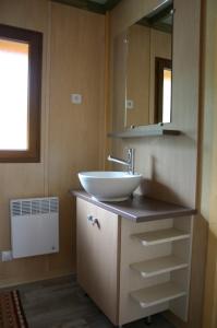 ein Badezimmer mit Waschbecken und Spiegel in der Unterkunft Chalets du Lac in Arcizans-Avant