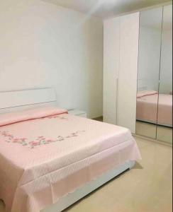 a bedroom with a pink bed and a mirror at Villa“La Salentina” in Castrignano del Capo